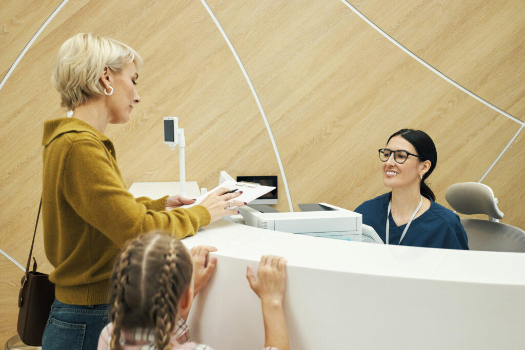 Woman With Child Checking In At Reception