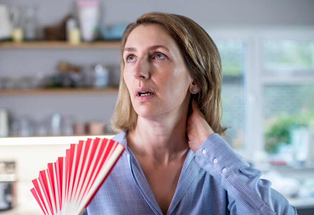 Mature Woman Experiencing Hot Flush From Menopause